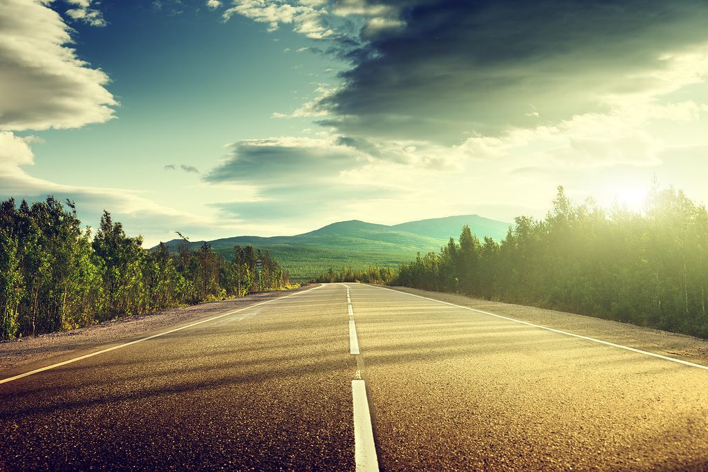 A road through a mountainous landscape, illustrating Kapsch TrafficCom's commitment to efficient and sustainable traffic solutions.