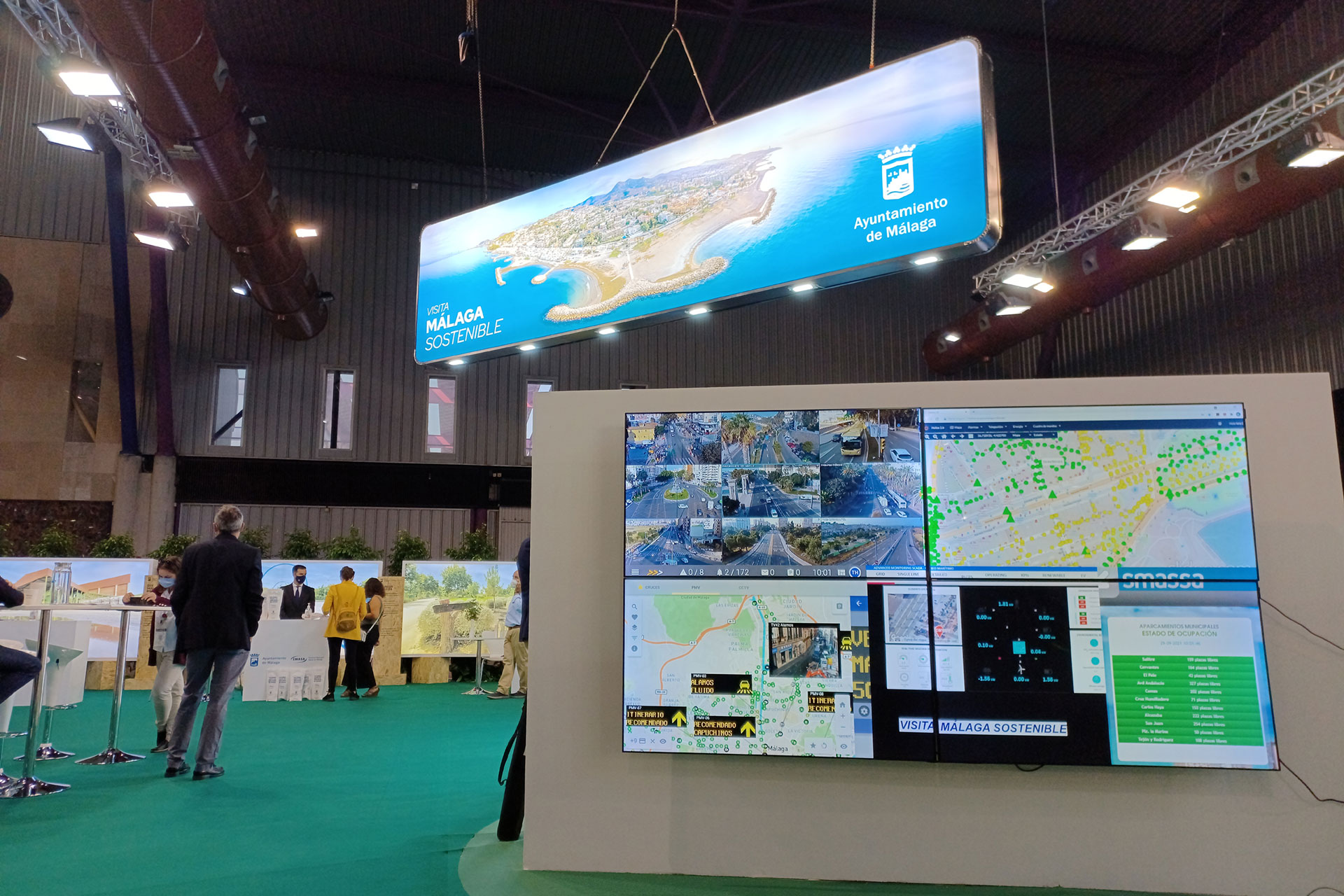 Ein Mann steht vor einem großen Display mit Karten.