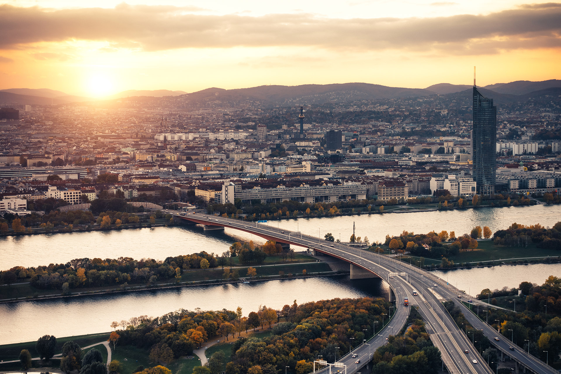 Eine Brücke über einen Fluss mit einer Stadt im Hintergrund, passend zur Verkehrsintelligenz-Lösung von Kapsch.