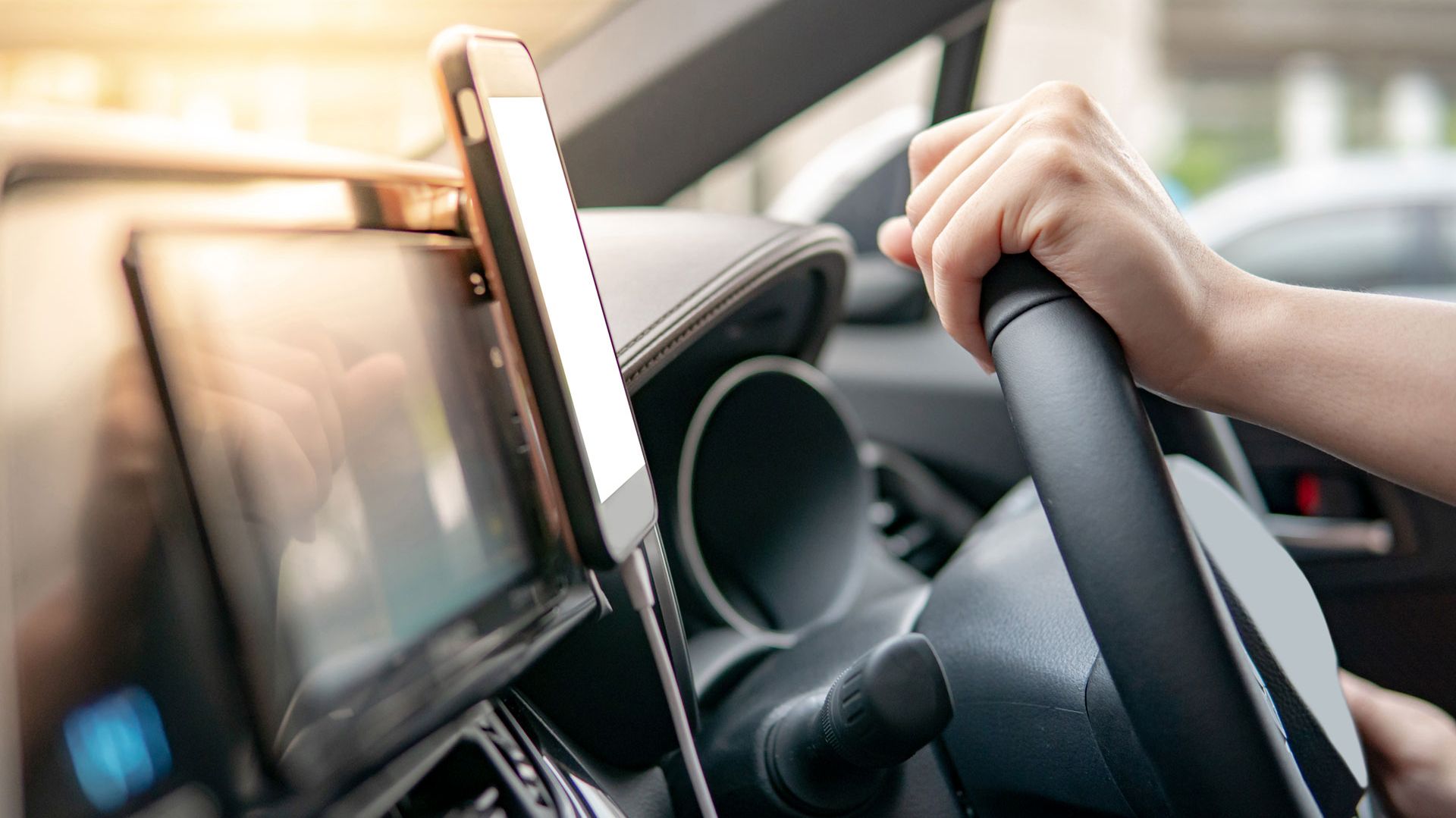 Eine Person hält das Lenkrad in einem Auto, im Kontext der Kapsch-Lösung für Straßenbenutzungsgebühren.